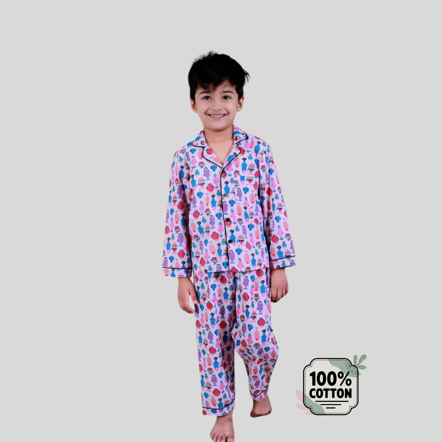 Child wearing a colorful pajama set on a plain background with a '100% Cotton' label.
